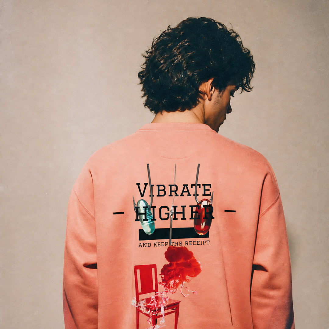 Model wearing the Vazzari Vibrate Higher Sweatshirt – Dusty Rose in a beige studio