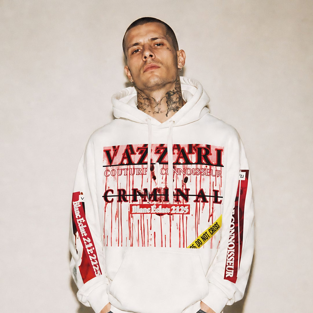 Model wearing the Vazzari Criminal Blanc Hoodie in a beige studio (man)