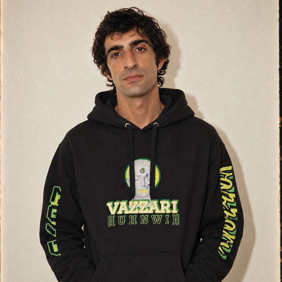 Model wearing the Vazzari UHNWI Hoodie in a beige studio